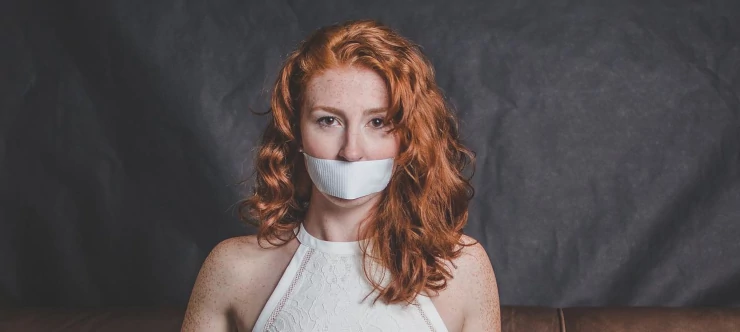 'Frau mit verbundenem Mund als Symbol zum Thema Redefreiheit'